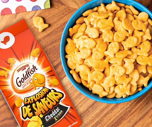 Goldfish® Explosion de Saveurs Cheddar Xtreme with blue bowl of Goldfish® crackers on table