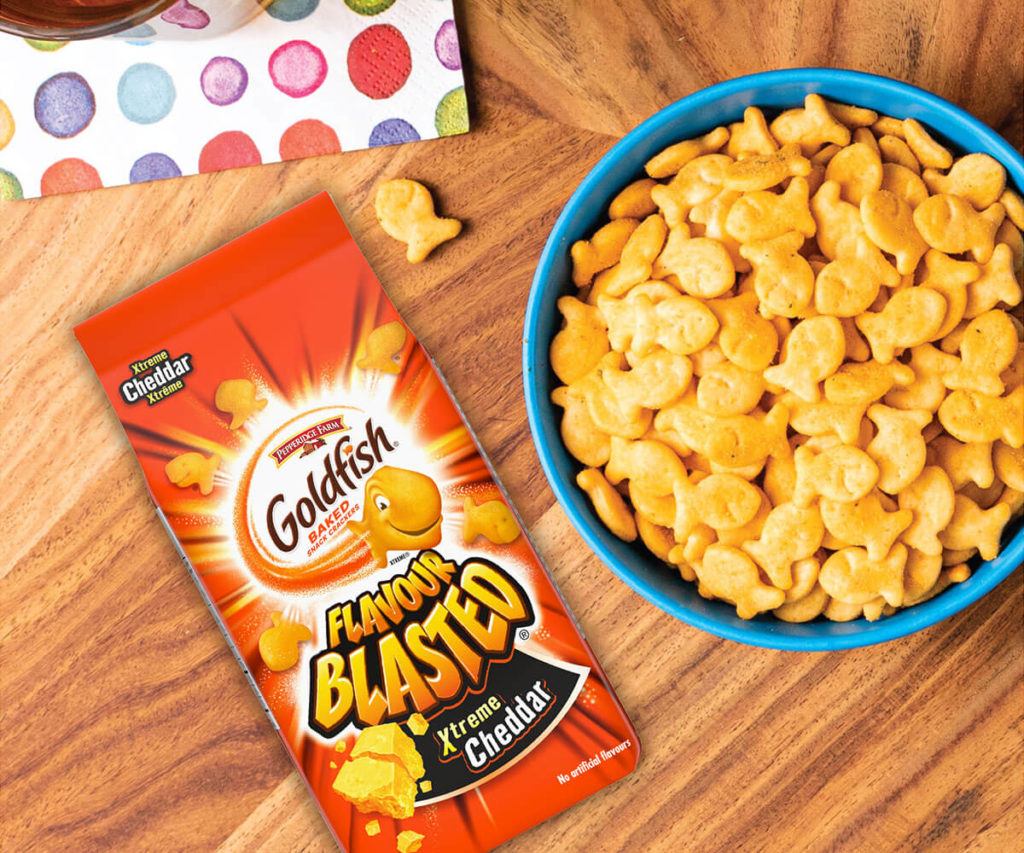 Goldfish® Flavour Blasted Xtreme Cheddar package with blue bowl of Goldfish® crackers on table