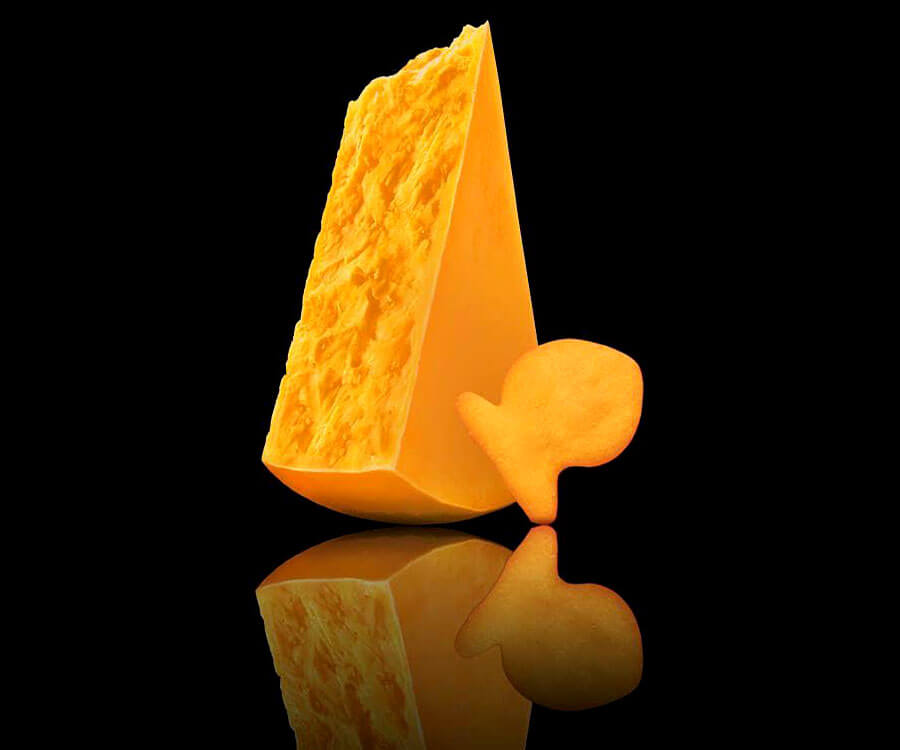 Goldfish® Mega Bite cracker with block of cheese on black background